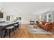 Open-concept living area featuring a kitchen island with seating, hardwood floors, and bright, natural light at 11021 Otis St, Westminster, CO 80020