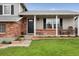 Inviting front porch with seating, complemented by a brick facade and landscaped garden beds at 11021 Otis St, Westminster, CO 80020