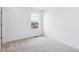 Bright bedroom with neutral carpeting and a large window at 2060 Chambers Rd, Brighton, CO 80601