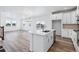 Open concept kitchen with white cabinets, island, and vinyl plank flooring at 2060 Chambers Rd, Brighton, CO 80601