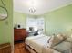 Sunlit bedroom featuring bright green walls, wood floors, and a corner window with a desk at 2635 N Clayton St, Denver, CO 80205