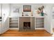 Close up of a cozy fireplace with white shelving on either side and light coming in from two windows at 2635 N Clayton St, Denver, CO 80205