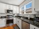 Charming kitchen with stainless appliances, black countertops, and ample natural light at 2635 N Clayton St, Denver, CO 80205