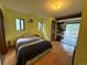 Cozy bedroom with two windows and wood-look flooring, leading to a sunroom at 274 Lincoln Dr, Idaho Springs, CO 80452