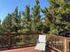 Relaxing deck space with a comfortable chair and gorgeous views of tall pine trees at 274 Lincoln Dr, Idaho Springs, CO 80452