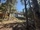 Exterior view of the house surrounded by pine trees and construction materials at 274 Lincoln Dr, Idaho Springs, CO 80452