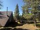 A-frame home in the woods with tall trees and a deck at 274 Lincoln Dr, Idaho Springs, CO 80452