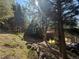A-frame home in the woods with tall trees and an off-road vehicle at 274 Lincoln Dr, Idaho Springs, CO 80452