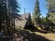 Scenic view of an A-frame home with a charming deck surrounded by towering pine trees at 274 Lincoln Dr, Idaho Springs, CO 80452