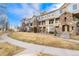 Tan townhouse building with stone accents, set against a blue sky at 1535 S Florence Way # 407, Aurora, CO 80247