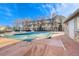 Community pool with a pool cover surrounded by fencing and multi-story tan buildings under a blue, partly cloudy sky at 1535 S Florence Way # 407, Aurora, CO 80247