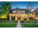 Charming two-story home with a manicured lawn and inviting front porch at twilight at 2324 S Columbine St, Denver, CO 80210