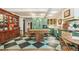 Charming eat-in kitchen with black and green checkerboard floor, central island, and built-in glass-front cabinets at 2324 S Columbine St, Denver, CO 80210