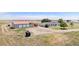 Aerial view showing a house, outbuildings, and extensive land, showcasing the property's potential at 8260 County Road 39, Fort Lupton, CO 80621