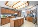 Open-concept kitchen featuring ample wooden cabinetry, a central island, and modern appliances at 8260 County Road 39, Fort Lupton, CO 80621