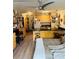 Cozy living area with kitchen featuring bar seating, hardwood floors, and modern ceiling fan at 909 N Logan St # 6D, Denver, CO 80203