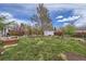Spacious backyard featuring a shed, mature trees, wooden fence, and lawn at 3600 Olive St, Denver, CO 80207