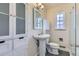 Bathroom featuring tiled floors, a pedestal sink, a toilet, and a glass door shower at 3600 Olive St, Denver, CO 80207