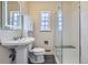 Bathroom featuring tiled floors, a pedestal sink, a toilet, and a glass door shower with bench at 3600 Olive St, Denver, CO 80207