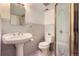 Bathroom featuring tiled walls, a pedestal sink, a toilet, and a glass door shower at 3600 Olive St, Denver, CO 80207