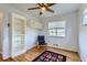 Bright bedroom featuring a ceiling fan, built-in shelving, hardwood floors, and a cozy chair at 3600 Olive St, Denver, CO 80207