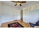 Light-filled bedroom with hardwood floors, closet, overhead fan, and stylish built-in shelving at 3600 Olive St, Denver, CO 80207
