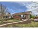 Charming brick home with a well-manicured front yard, inviting walkway, and cozy seating area at 3600 Olive St, Denver, CO 80207