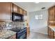 Kitchen showcasing granite counters, tiled backsplash, and modern appliances at 3600 Olive St, Denver, CO 80207