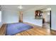 Open-concept living space with hardwood floors, a partial view of the kitchen, and plenty of potential at 3600 Olive St, Denver, CO 80207