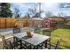 Landscaped backyard featuring a patio set and a variety of outbuildings at 169 Emerald St, Broomfield, CO 80020