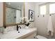 Stylish bathroom featuring a marble-look shower, a white vanity, and decorative accents including plants and artwork at 169 Emerald St, Broomfield, CO 80020
