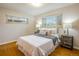 A cozy bedroom featuring hardwood floors, two windows, and neutral decor with stylish bedside tables and lamps at 169 Emerald St, Broomfield, CO 80020
