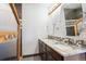 Bathroom with dual sinks, granite countertops, unique mirrors, and stylish tile accents at 1937 Jay St, Lakewood, CO 80214