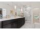 Elegant bathroom featuring dual sinks with gold hardware, marble floors and walls, and a glass-enclosed shower at 8000 N 41St St, Longmont, CO 80503