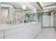 Bright bathroom features double sinks, white cabinetry, marble floors, and glass-enclosed shower at 8000 N 41St St, Longmont, CO 80503