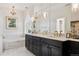 Bright bathroom features a soaking tub, dual vanity with black cabinets, and luxurious finishes at 8000 N 41St St, Longmont, CO 80503