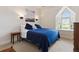 Simple bedroom with blue bedding, sconce lighting, and an arched window providing soft natural light at 8000 N 41St St, Longmont, CO 80503
