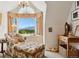 Cozy bedroom featuring floral armchair, mountain views from arched window, and natural light at 8000 N 41St St, Longmont, CO 80503