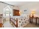 Bright bedroom with patterned bedding, vintage wardrobe, and cozy seating beneath arched window at 8000 N 41St St, Longmont, CO 80503