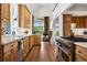 Gourmet kitchen featuring custom cabinets, stainless steel appliances, and a brick archway leading to the living area at 8000 N 41St St, Longmont, CO 80503