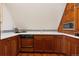 A compact kitchen features custom wood cabinetry, sleek countertops, and stainless steel appliances under a vaulted ceiling at 8000 N 41St St, Longmont, CO 80503