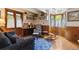 Cozy living room with wood-paneled walls, built-in bookshelves, and comfortable seating near a bay window at 8000 N 41St St, Longmont, CO 80503