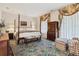 Spacious bedroom with a four-poster bed, decorative curtains, and patterned furnishings at 8000 N 41St St, Longmont, CO 80503