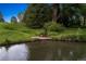 Picturesque pond with clear water, lush greenery, and a small wooden bridge, creating a tranquil atmosphere at 8000 N 41St St, Longmont, CO 80503