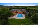 Aerial view of a luxury home featuring a stunning pool, lush lawn, and mature trees against a scenic landscape at 8000 N 41St St, Longmont, CO 80503