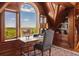 Wood-paneled study features built-in shelving, a desk overlooking scenic views, and a cozy atmosphere at 8000 N 41St St, Longmont, CO 80503