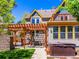 This backyard has a pergola, hot tub, lush grass, and ample seating for relaxation at 4348 Umatilla St, Denver, CO 80211