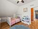 Cozy bedroom with light hard wood floors, ceiling fan and views of exposed brick through the doorway at 4348 Umatilla St, Denver, CO 80211