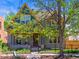 Charming two-story home featuring a unique blue and gold trim and a well-manicured front yard with metal fencing at 4348 Umatilla St, Denver, CO 80211
