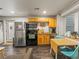 Functional kitchen with stainless steel refrigerator and appliances, complemented by light wood cabinets at 4348 Umatilla St, Denver, CO 80211